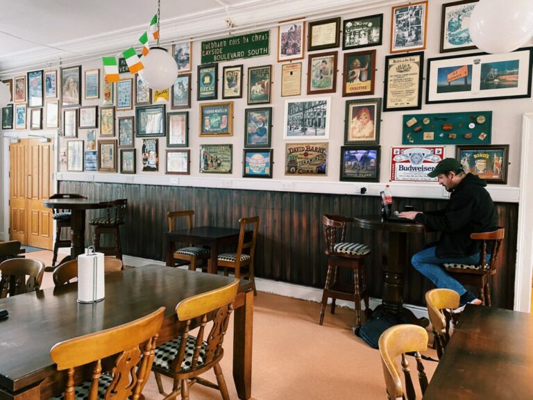 A room with tables and a wall with lots of pictures at Canbe Hostels - Gardiner House