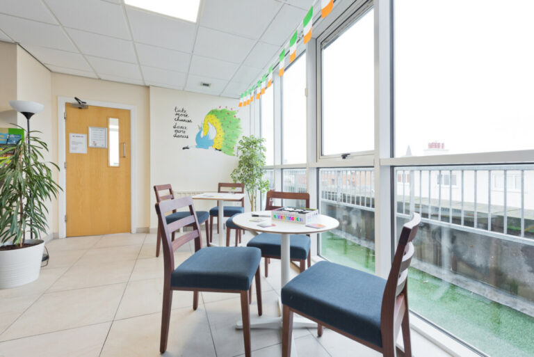 Tables near a window at Canbe Hostels - Garden Lane