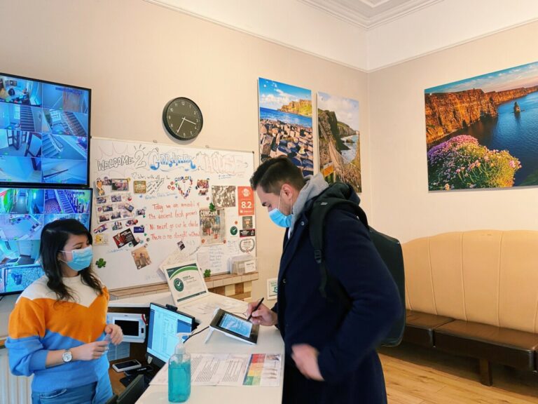 Canbe Hostels - Gardiner House reception and a guest signing something on an iPad