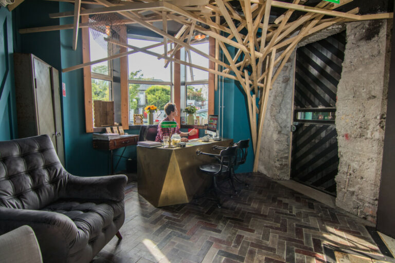 Hangout area with chairs, windows, and cool wood architecture at the reception area in The Nest Boutique Hostel Galway Ireland