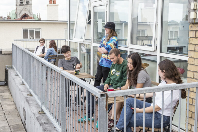 Outside balcony at Canbe Hostels - Garden Lane with guests hanging out