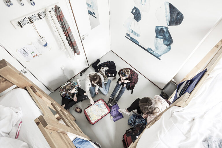 Bird's eye view of guests socializing in a room at Cocomama hostel